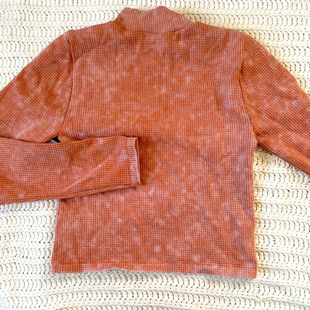 Peach colored waffle weave mock turtleneck.